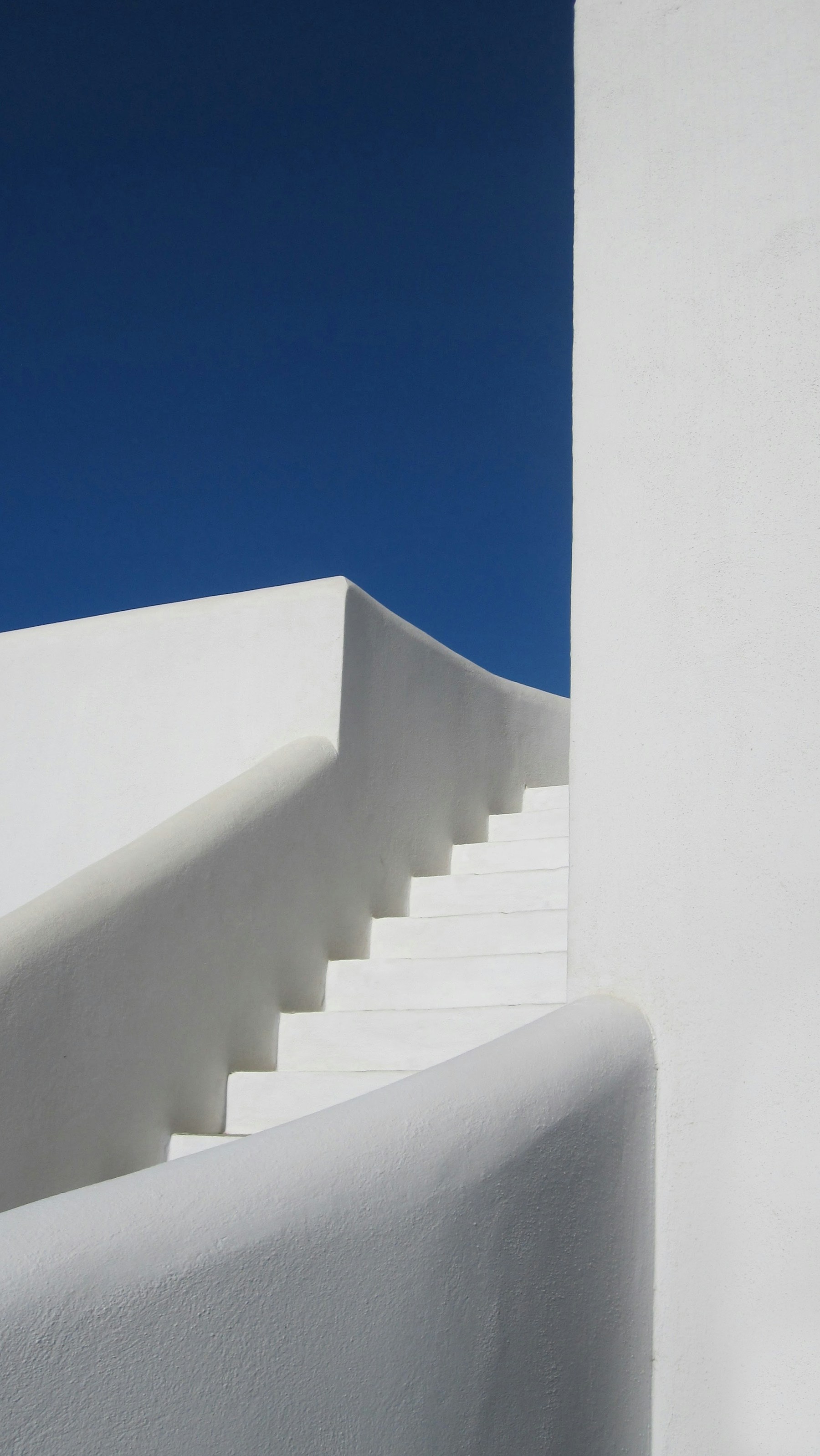 Escalera blanca que asciende hacia un cielo azul
